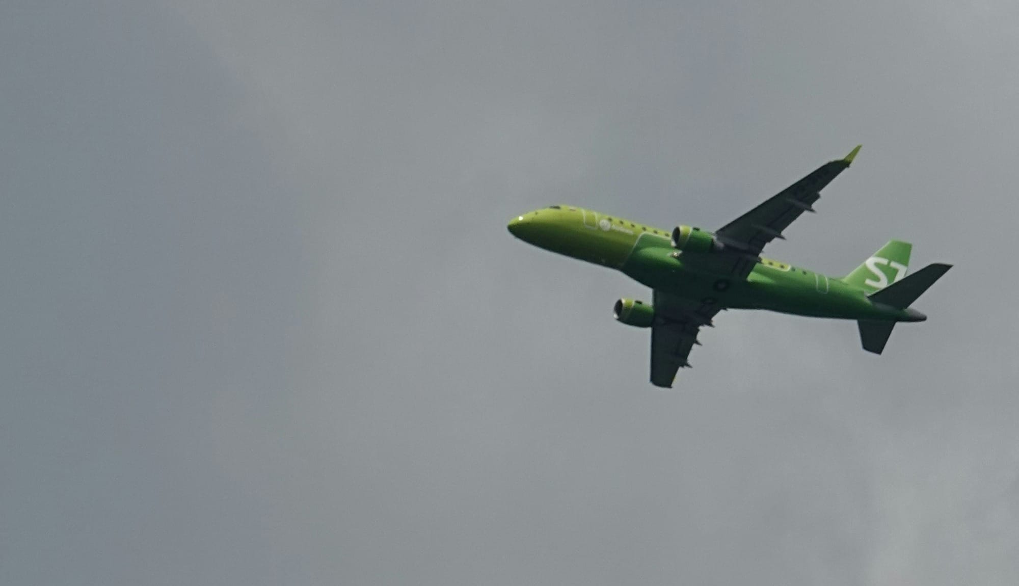 green airplane flying in the sky