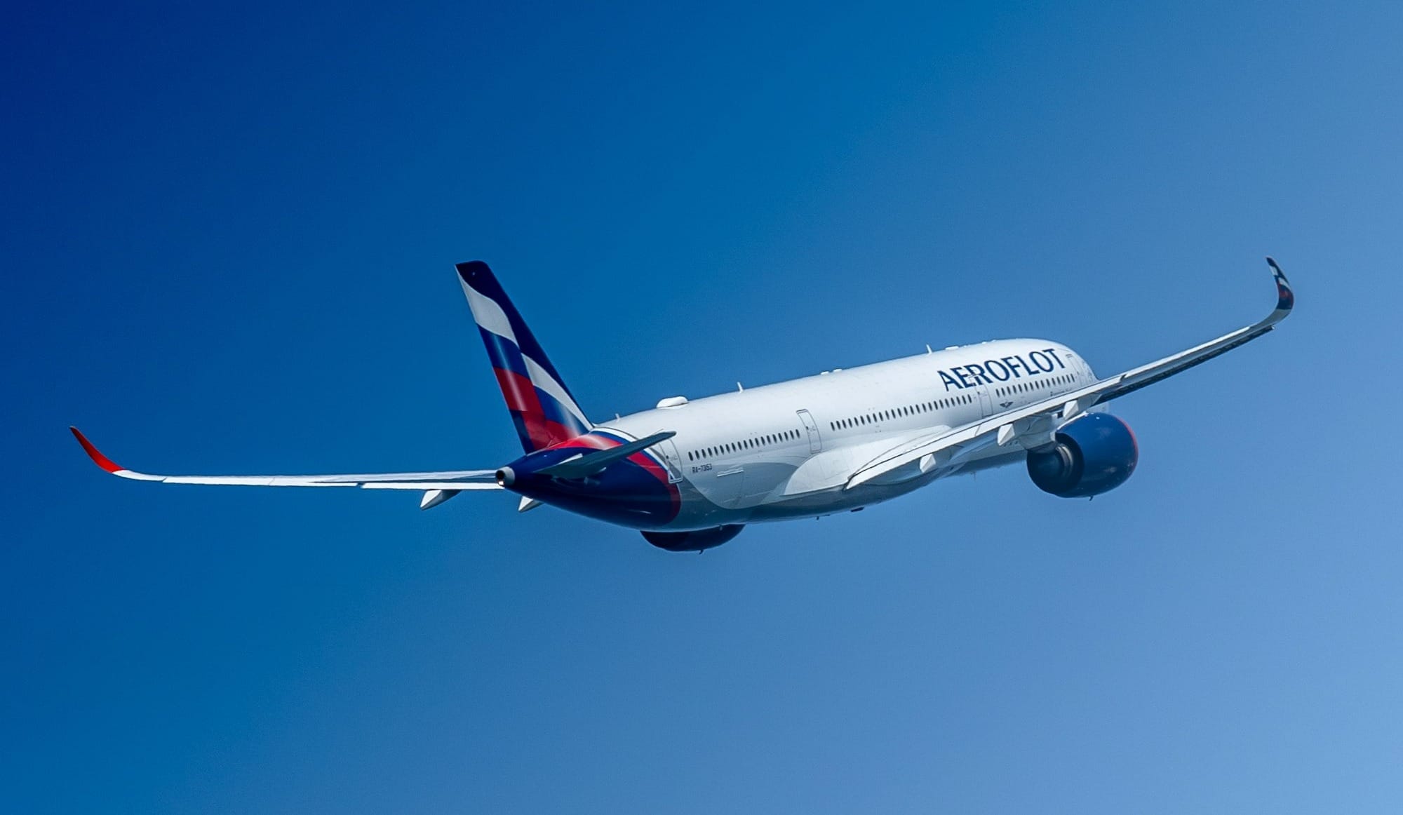 a large commercial airplane flying through a blue sky